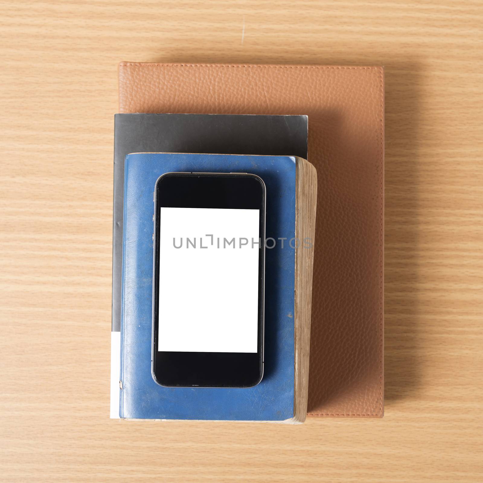 stack of book and smart phone on wood background