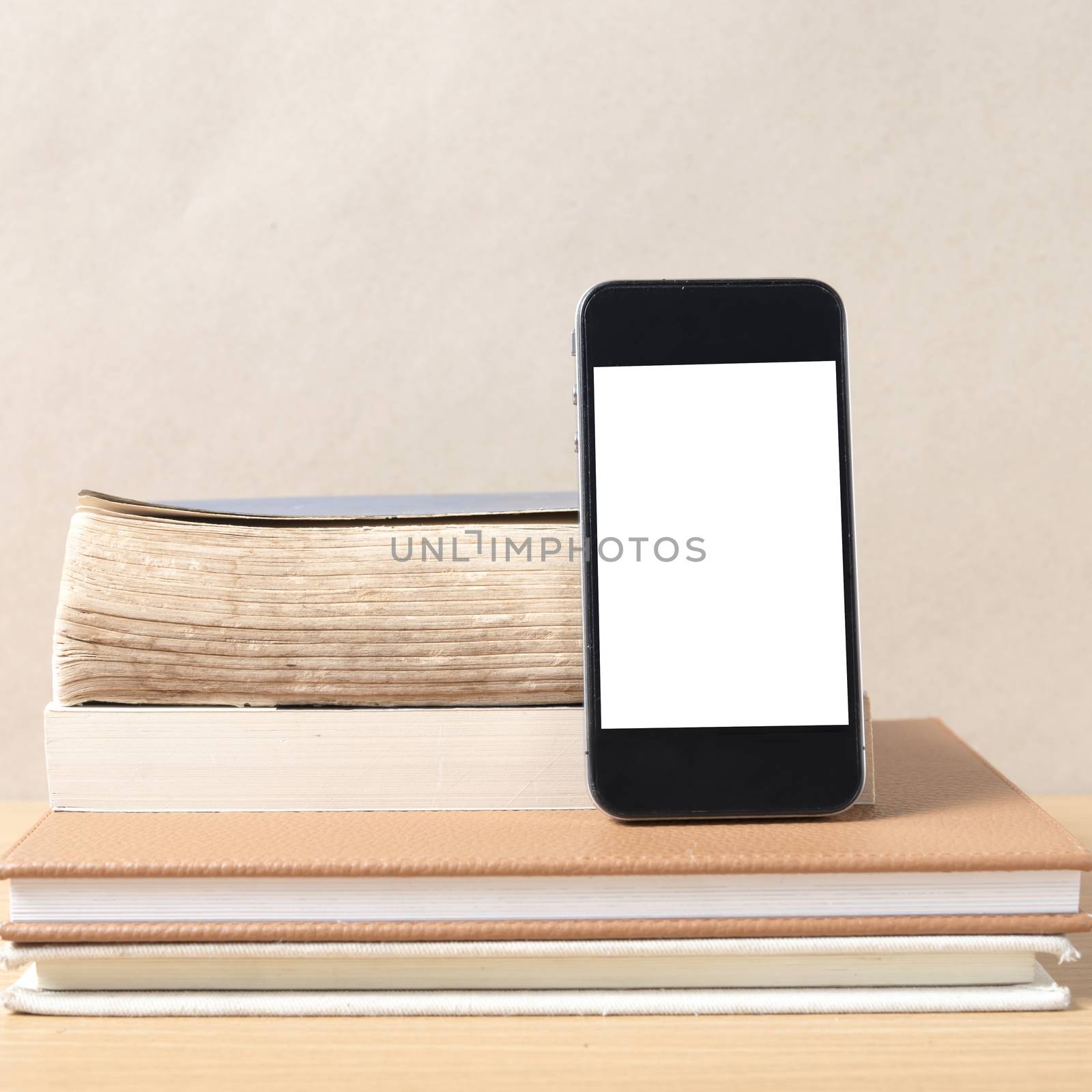 stack of book and smart phone on wood background