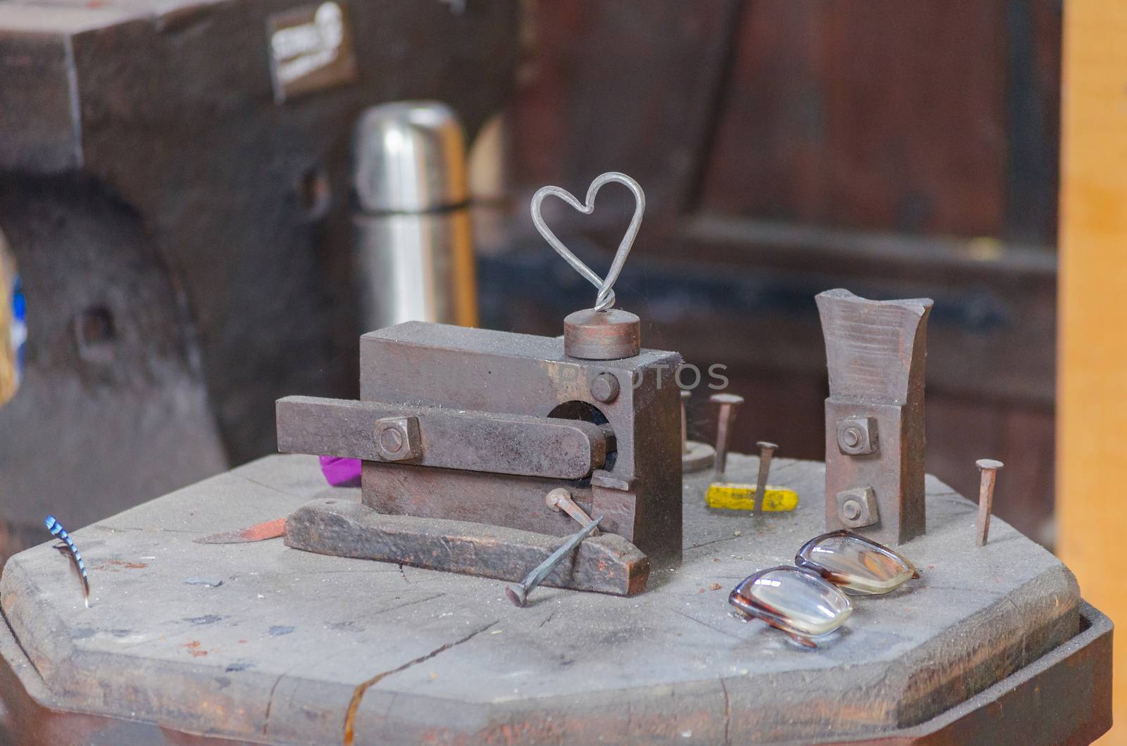 An old abandoned locksmith shop. Pictured anvil and different tools and objects.