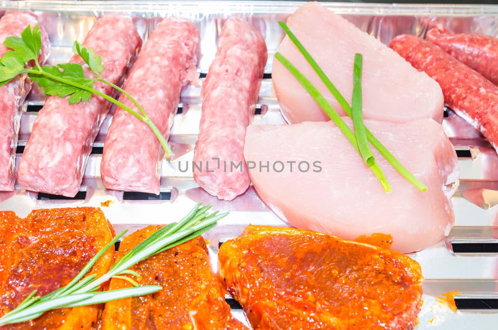 Close up various meats seasoned ready to grill.