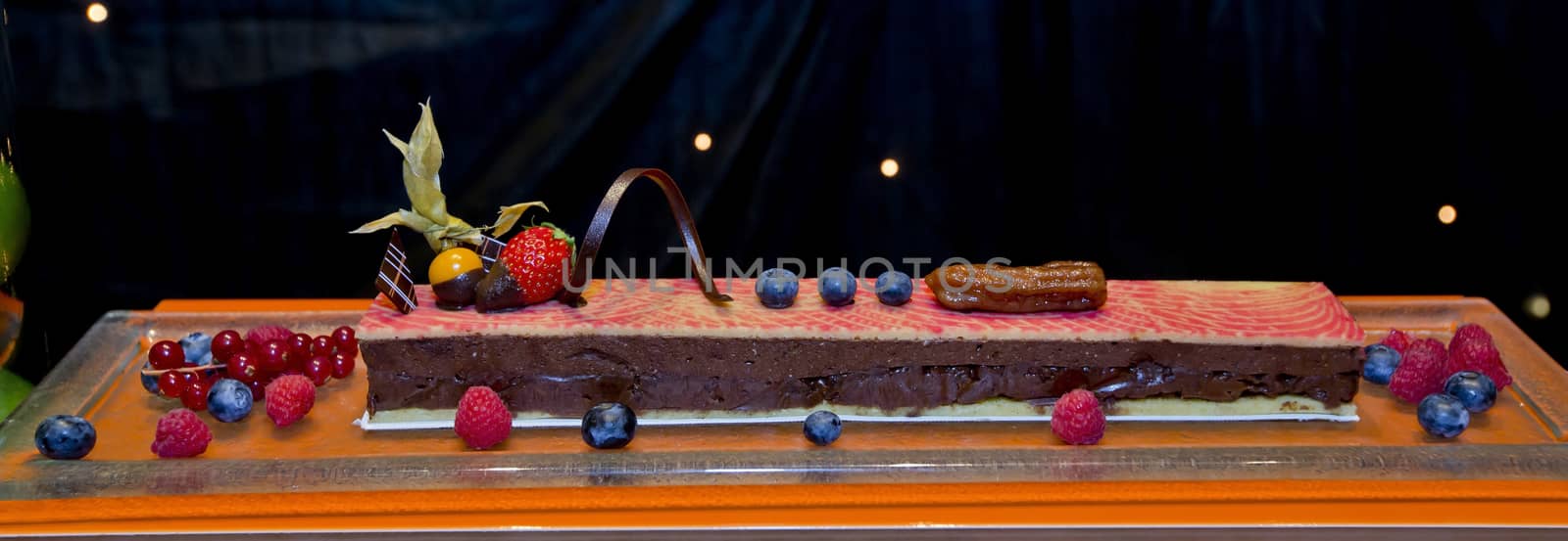 Dark chocolate cake with fresh fruit topping and around display in Party