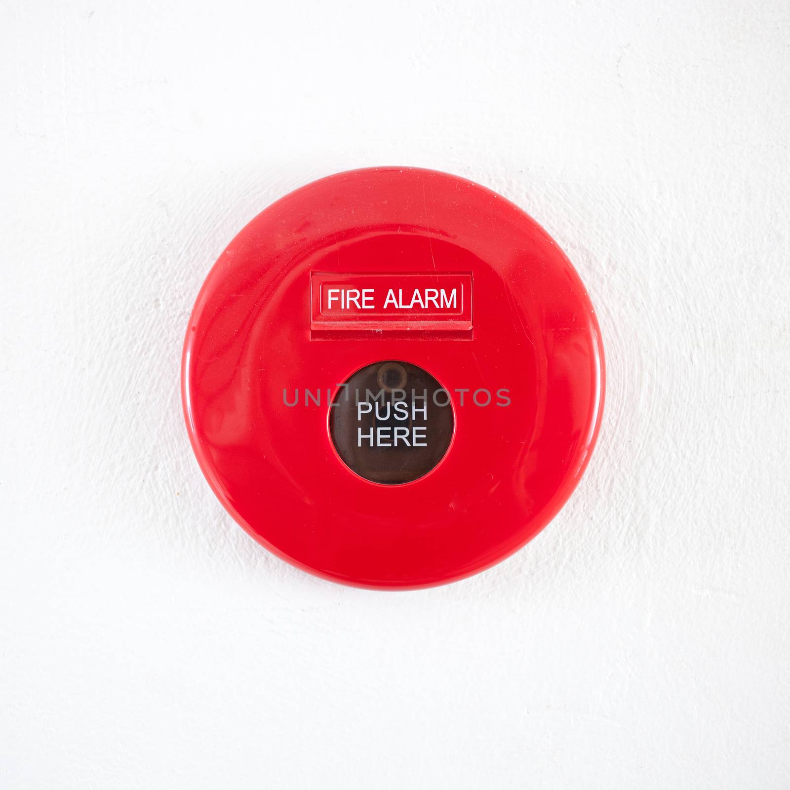Fire alarm on a white concrete wall by nopparats