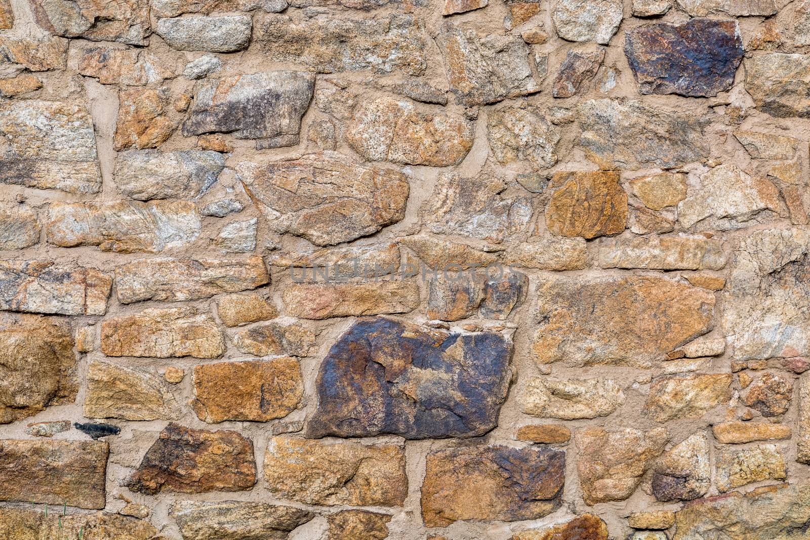 background and texture of old stone wall built with irregular sandstone blocks