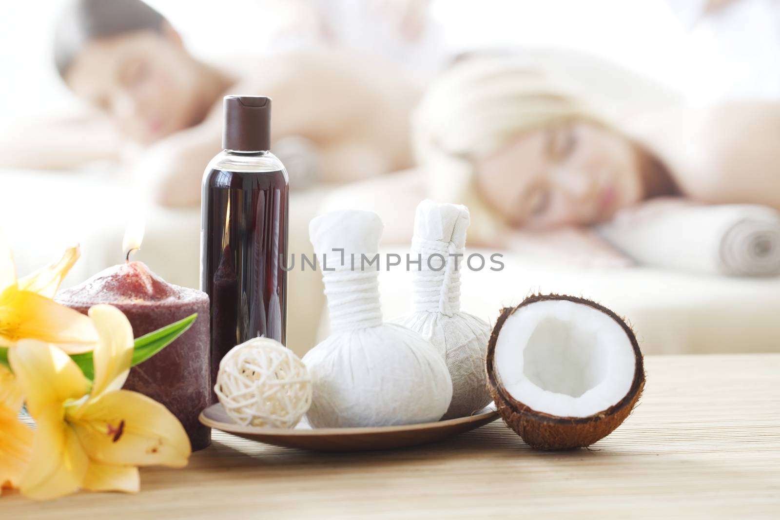 Spa massage tools and women getting massage on background
