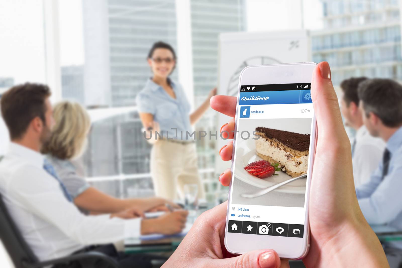 Hand holding smartphone against cup of coffee and desert