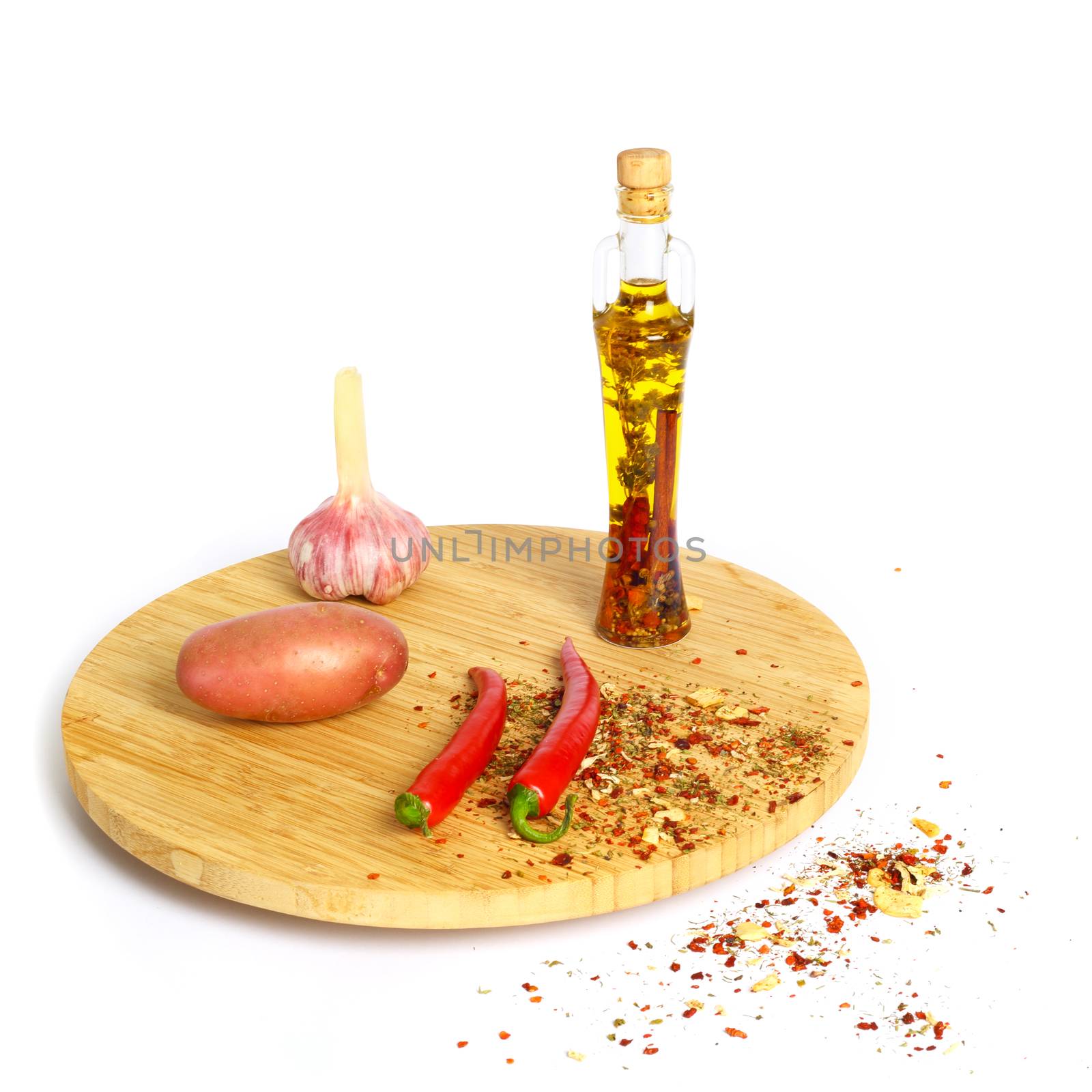 Spices and bottle of cooking oil on plank isolated on white background