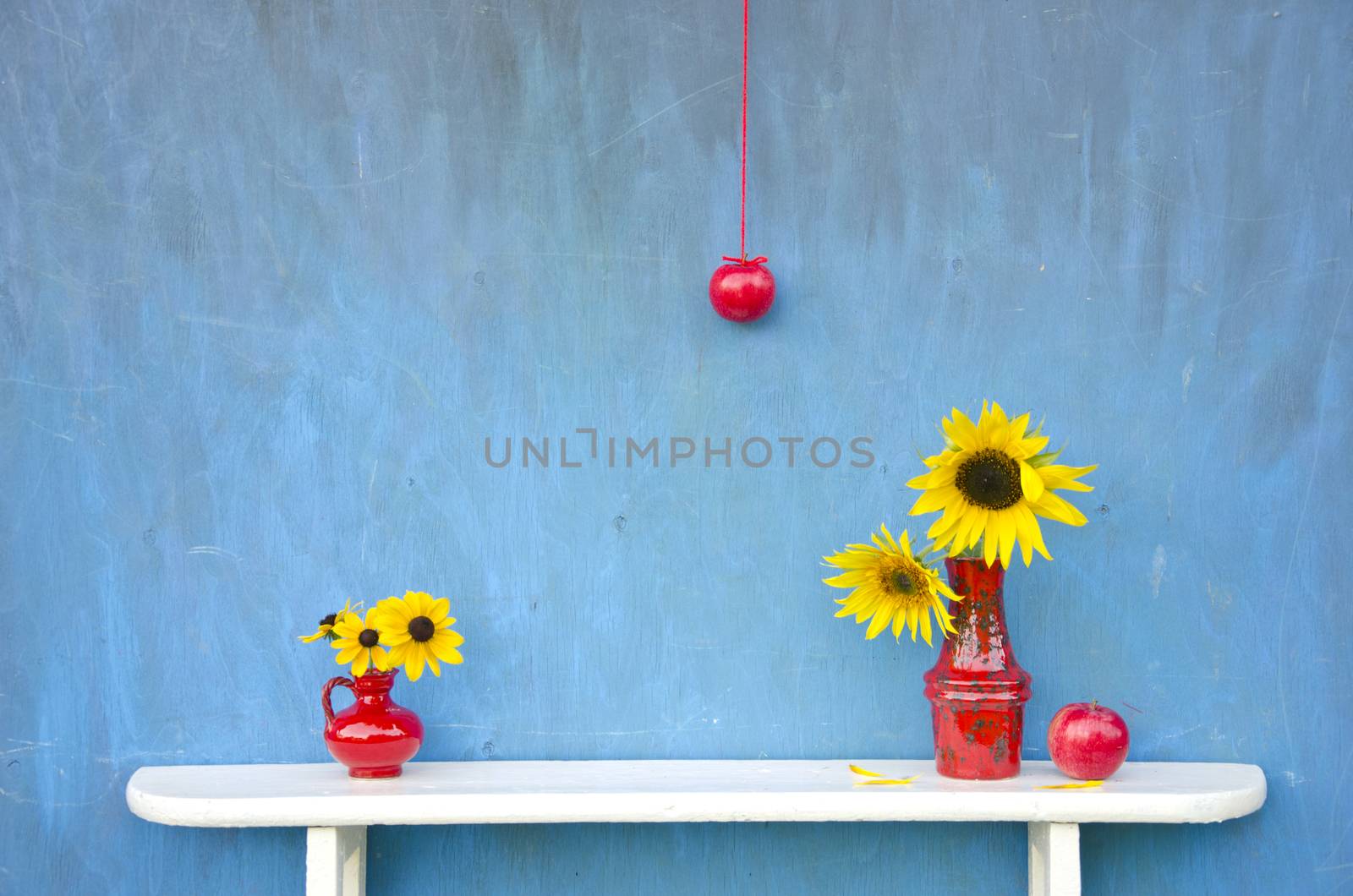 summer still-life with red vases, flowers and apples on white shelf