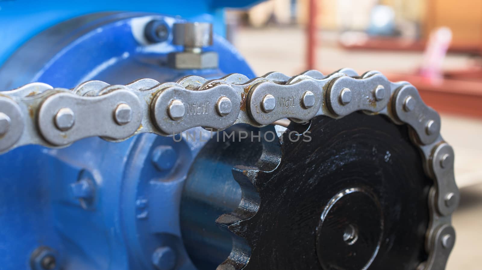 Close-up of chain and sprocket. Very shallow depth of field with a couple of chain links in focus.