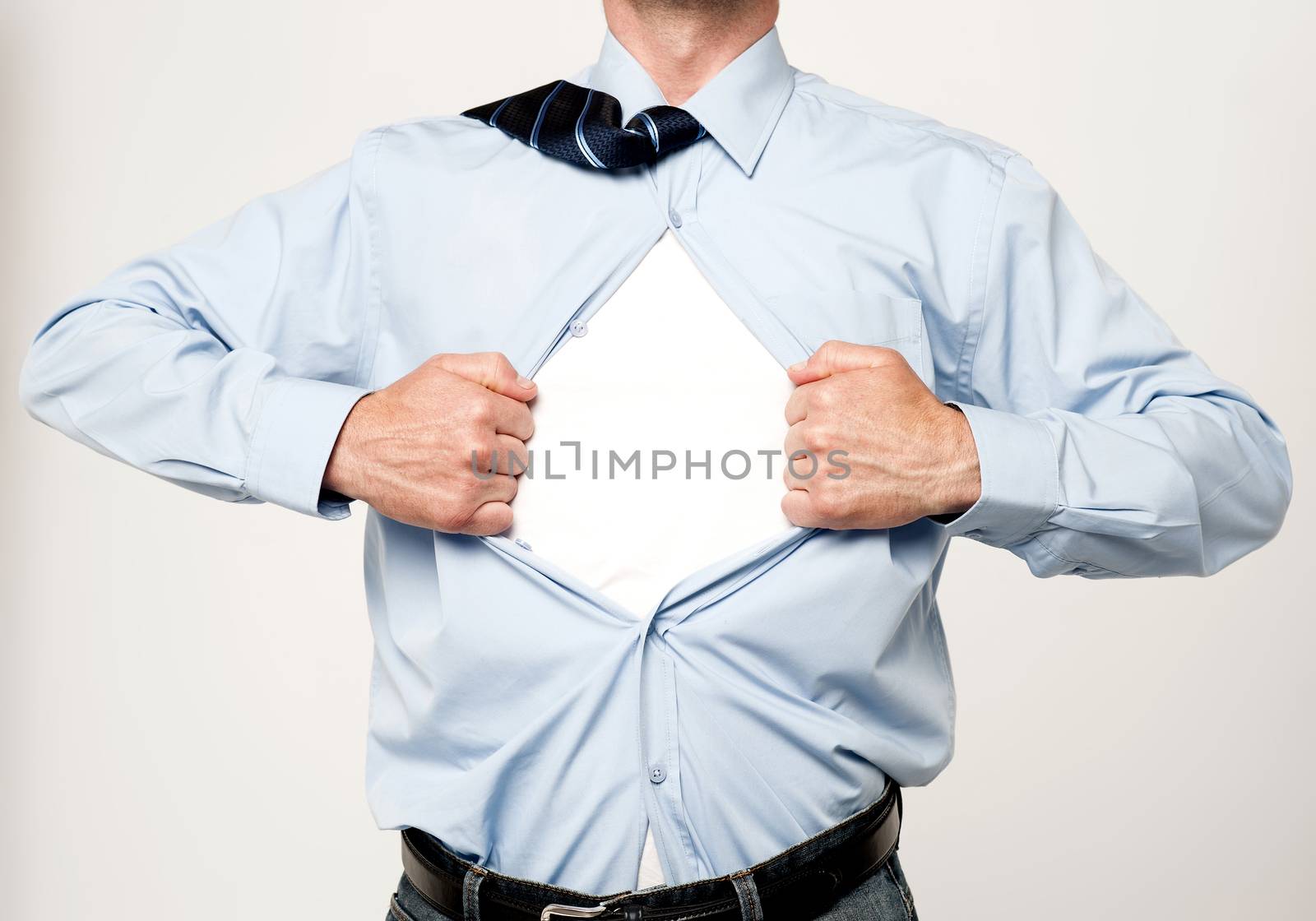 Superhero executive tearing his shirt by stockyimages