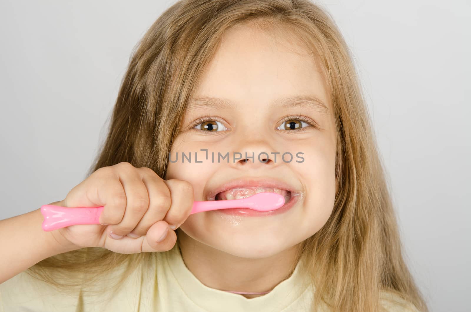 A girl of six years of brushing his teeth with a toothbrush