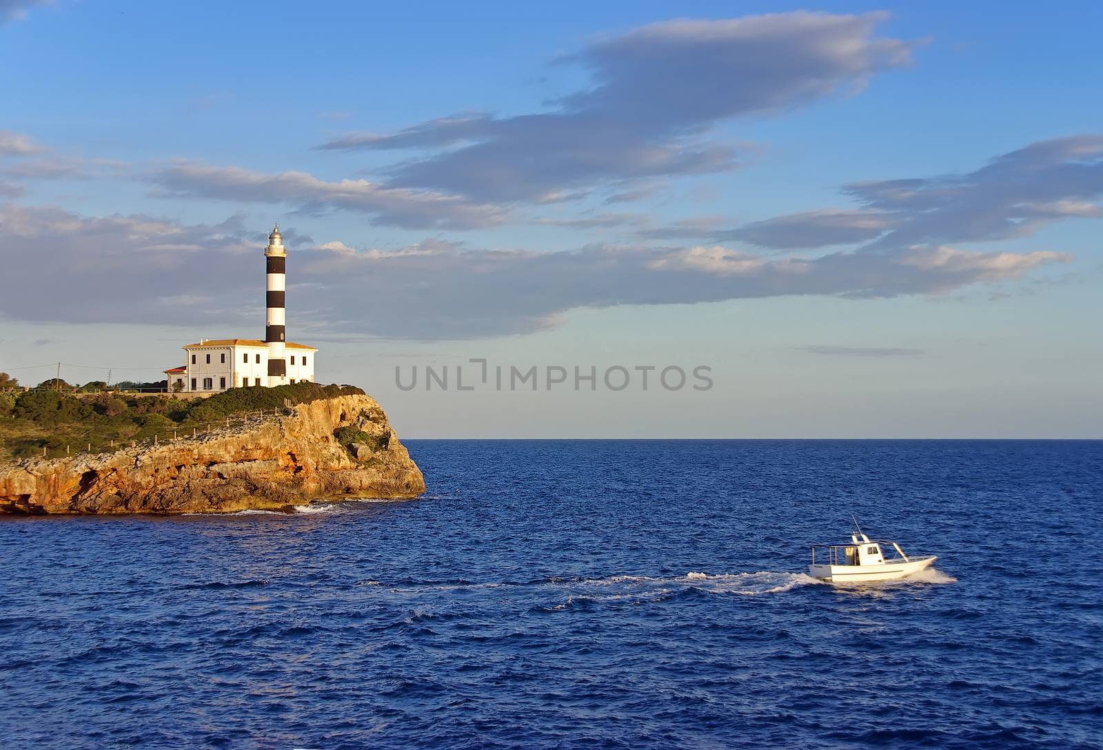 Boat navigating near an ancient lighhouse in spain