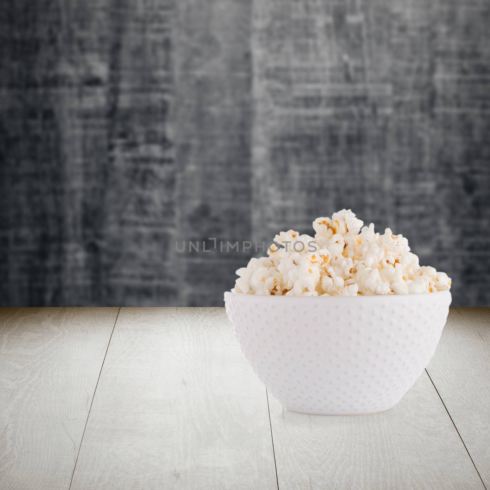 Pop corn bowl on wood table background.