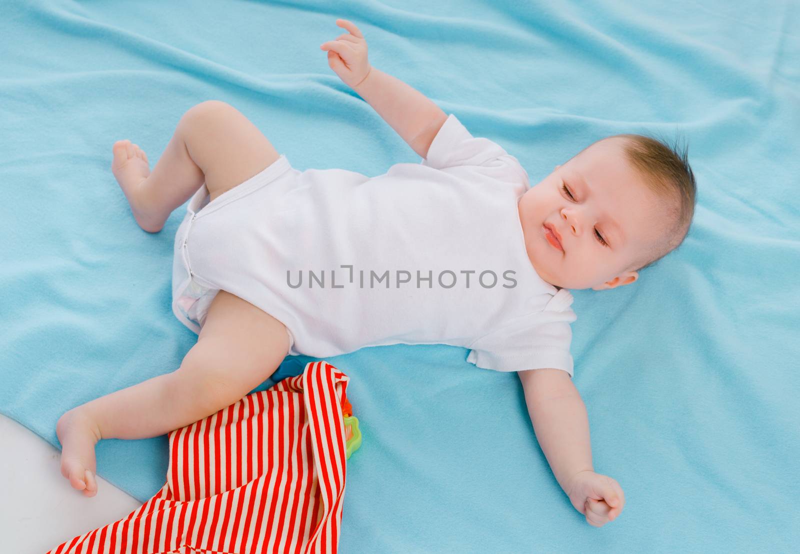 dissatisfied baby lying on a blue blanket