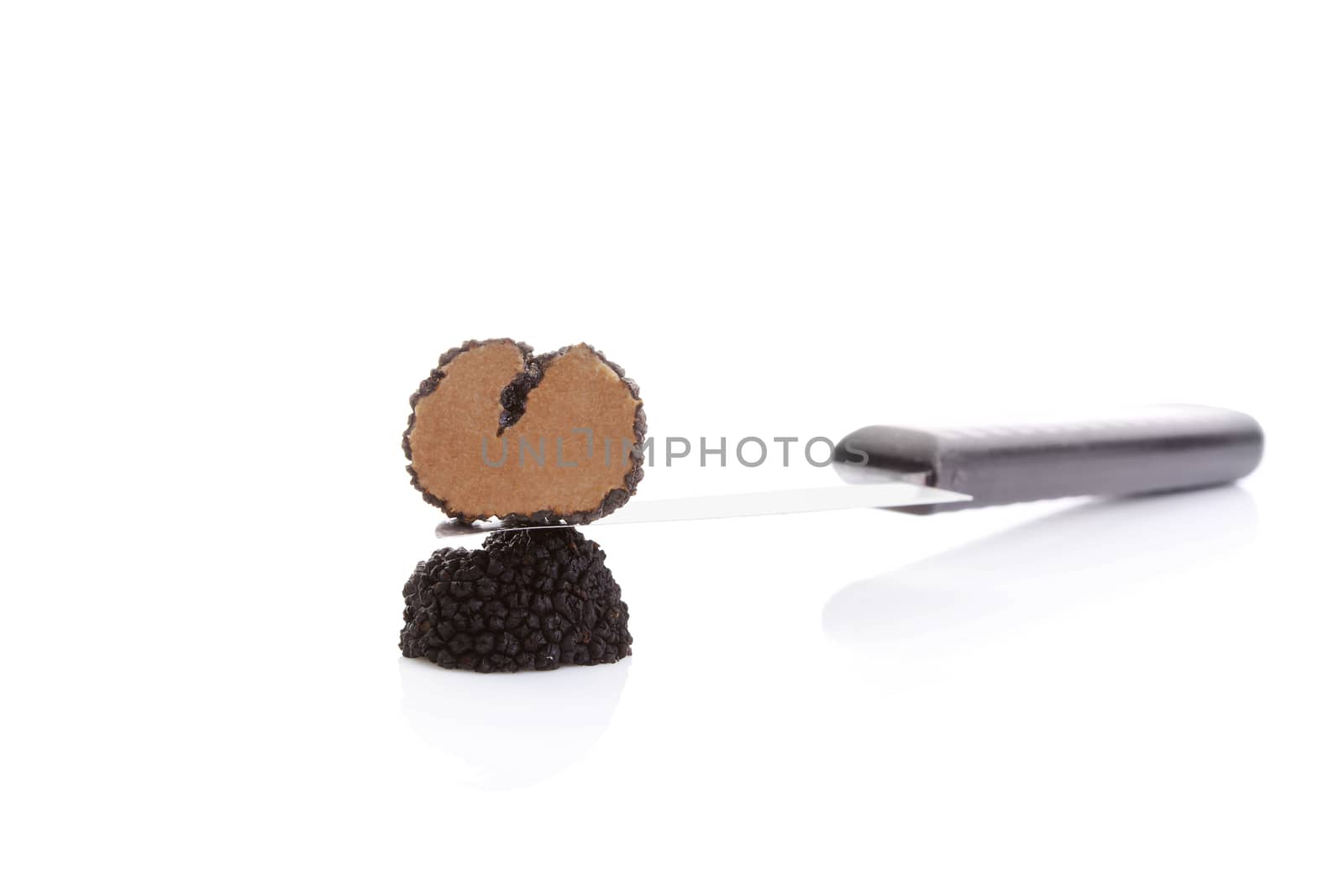 Cut truffles with knife isolated on white background. Luxurious culinary cooking ingredients.