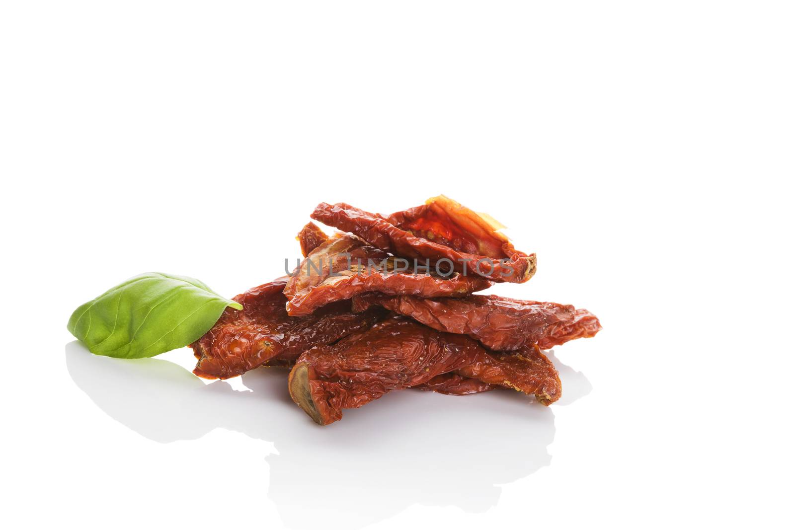 Sundried tomato with fresh basil herbs isolated on white background. Culinary italian eating.