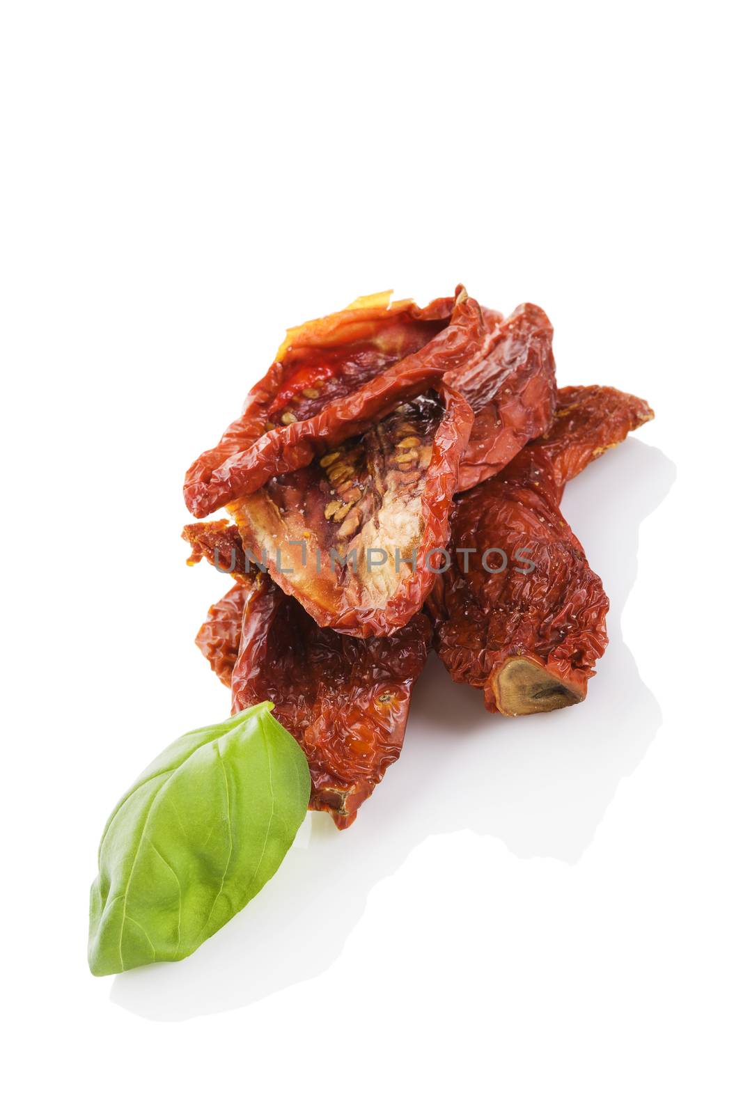 Sundried tomato with fresh basil herbs isolated on white background. Culinary italian eating.