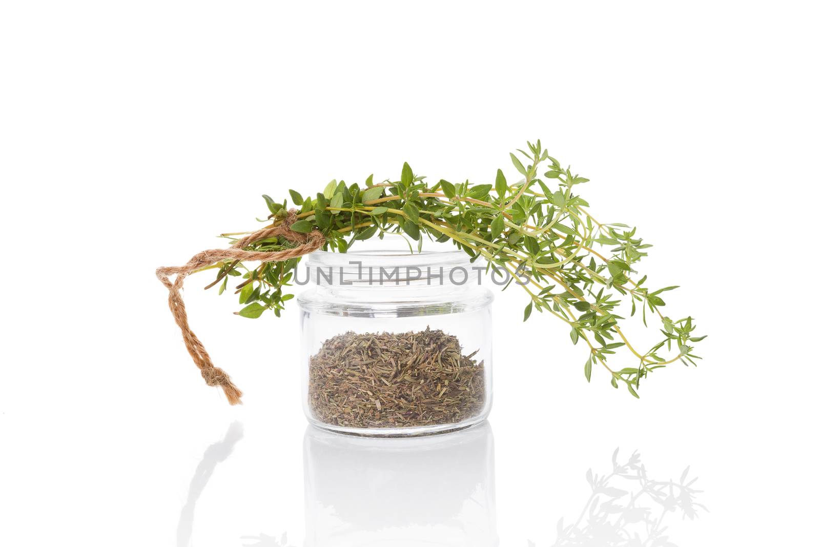 Fresh thyme and dry thyme spice in glass jar isolated on white background. Culinary healthy aromatic herbs. Culinary arts.