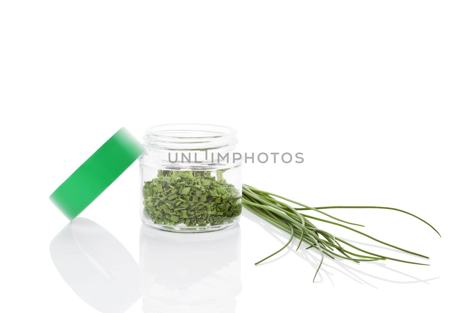 Fresh chives and dry chive spice in glass jar isolated on white background. Culinary healthy aromatic herbs. Fines herbes, culinary arts.