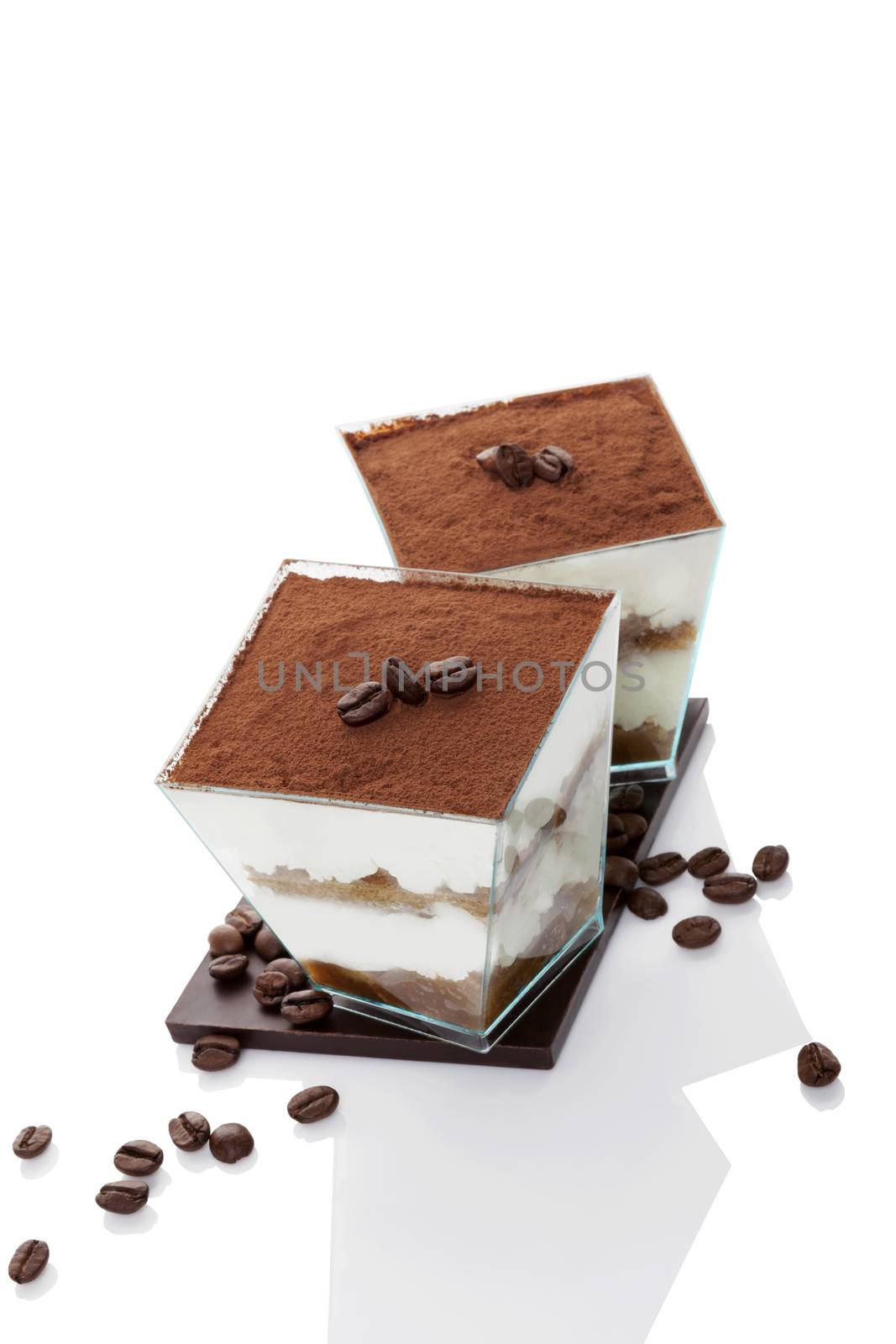 Tiramisu dessert on chocolate bar with coffee beans isolated on white background. Italian sweet dessert concept.