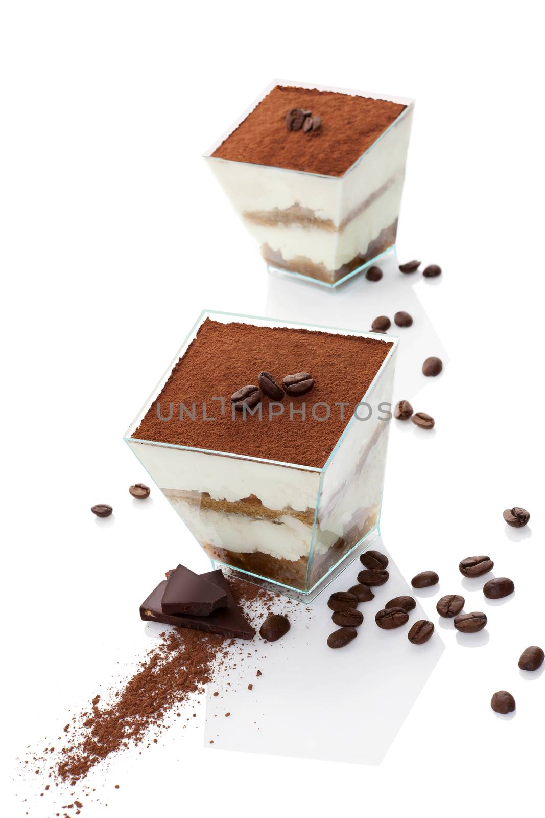 Tiramisu dessert on chocolate bar with coffee beans isolated on white background. Italian sweet dessert concept.