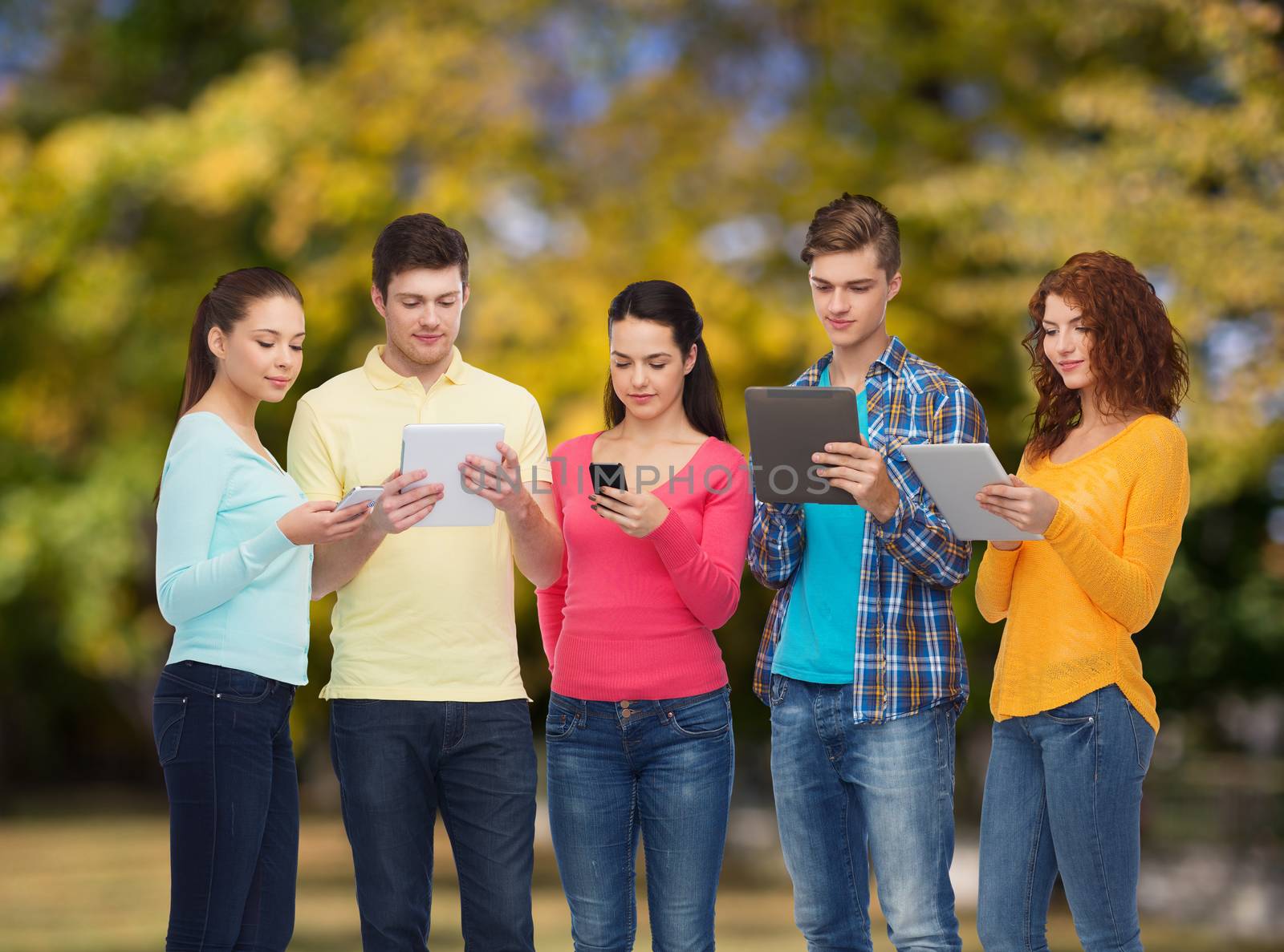 group of teenagers with smartphones and tablet pc by dolgachov