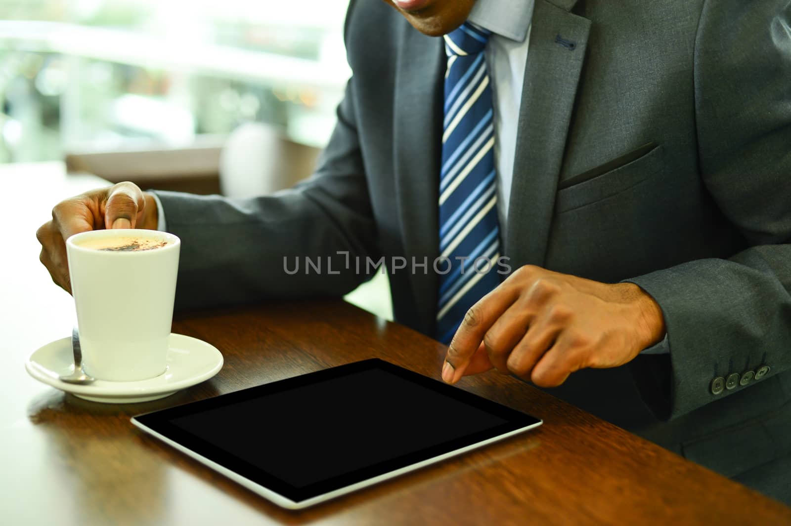 Businessman operating his digital tablet at cafe