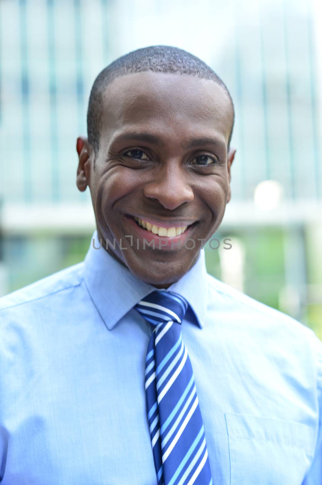 Happy male executive posing by stockyimages