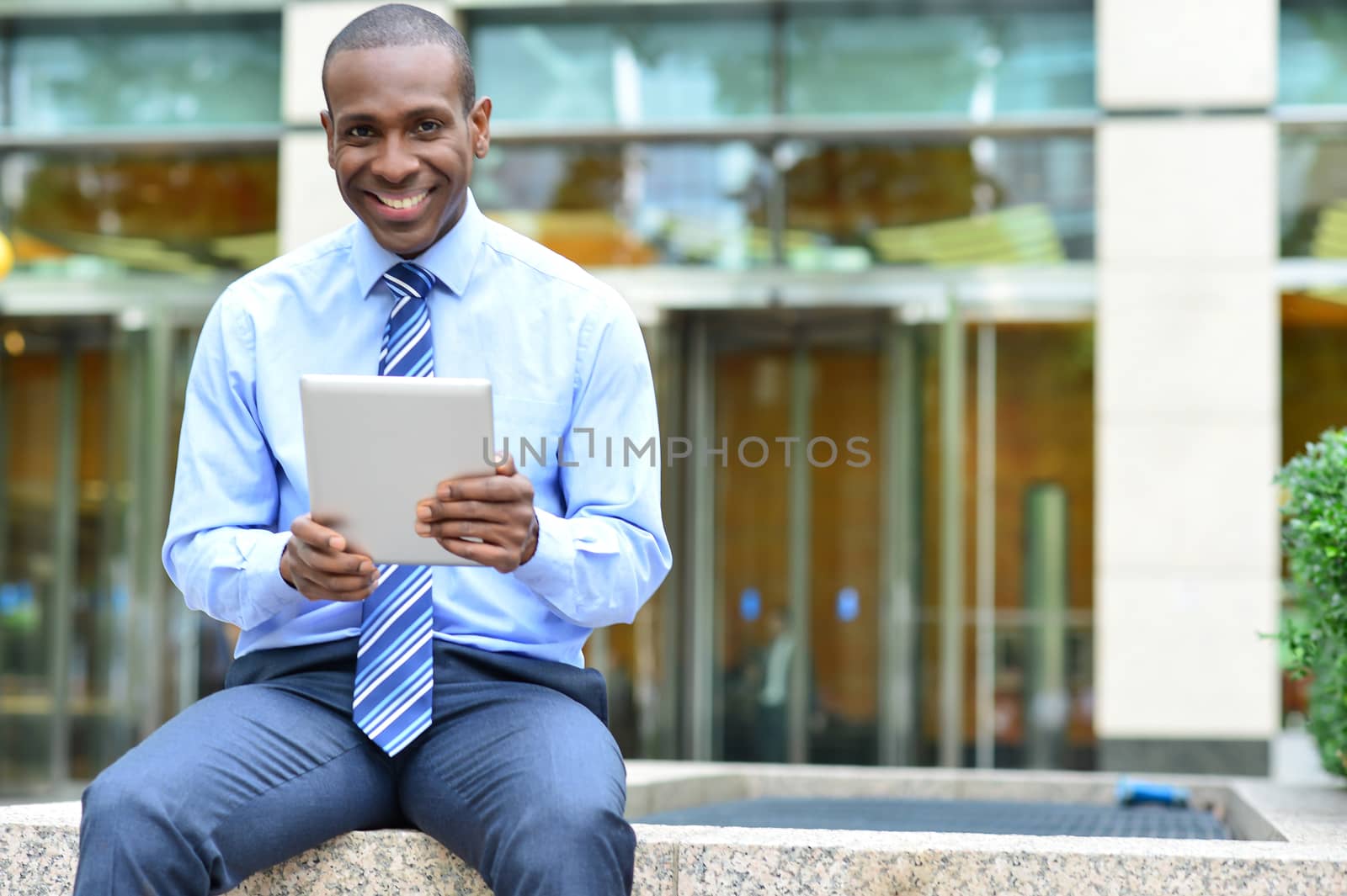 Corporate male siting outdoors with his new tablet pc