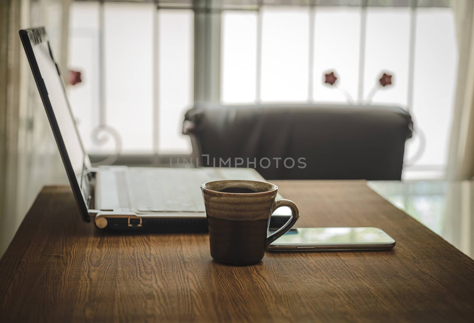 Business work place with cup of coffee smartphone and laptop.