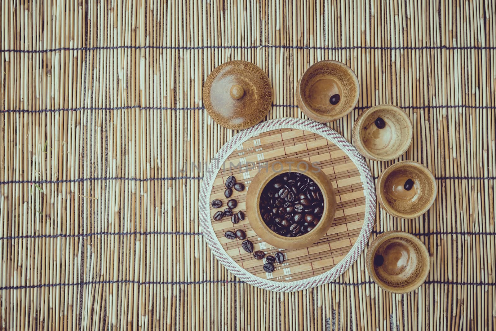 Coffee beans and coffee cup set on bamboo wooden background.Photo in retro color image style, Soft focus.