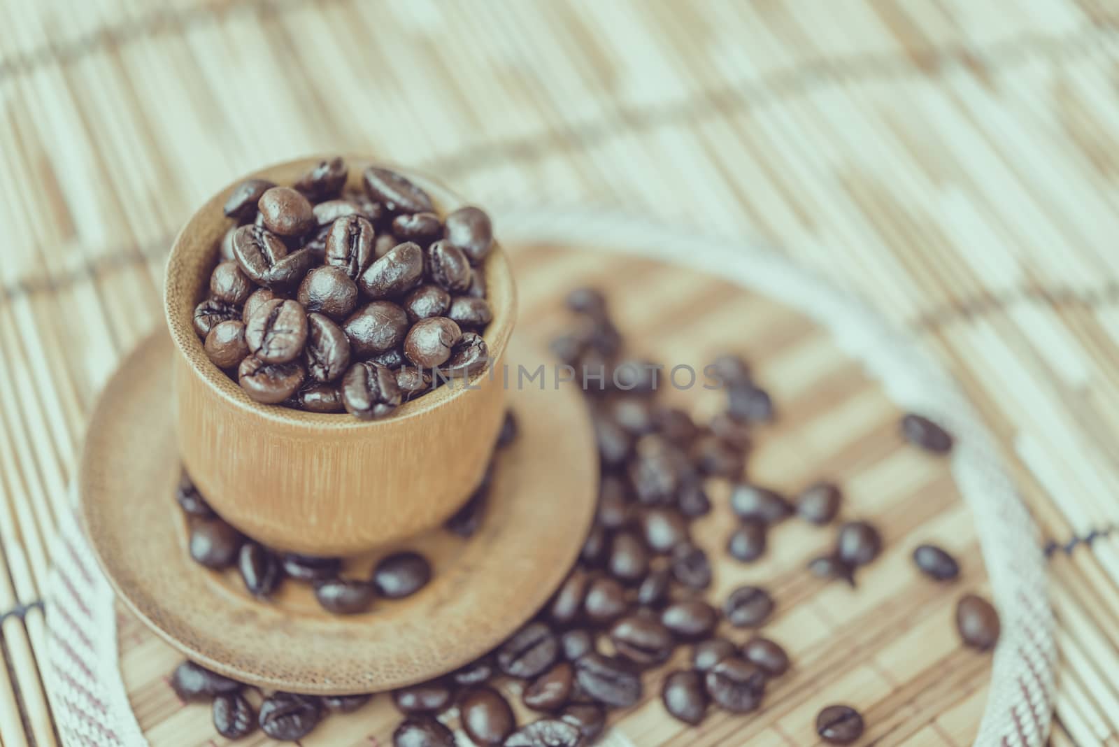 Coffee beans and coffee cup set on bamboo wooden background.Photo in retro color image style, Soft focus.