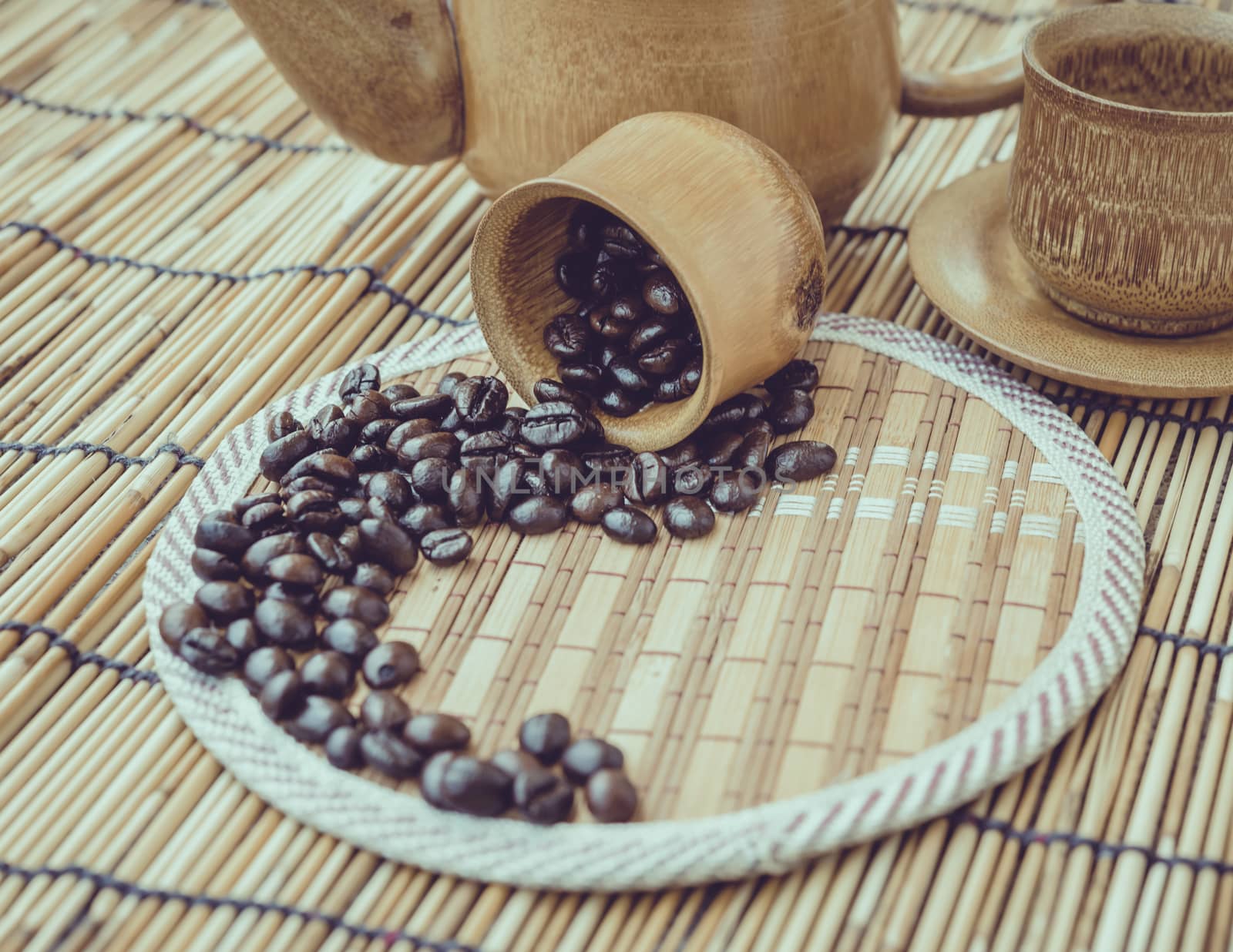 Coffee beans and coffee cup set on bamboo wooden background.Photo in retro color image style, Soft focus.