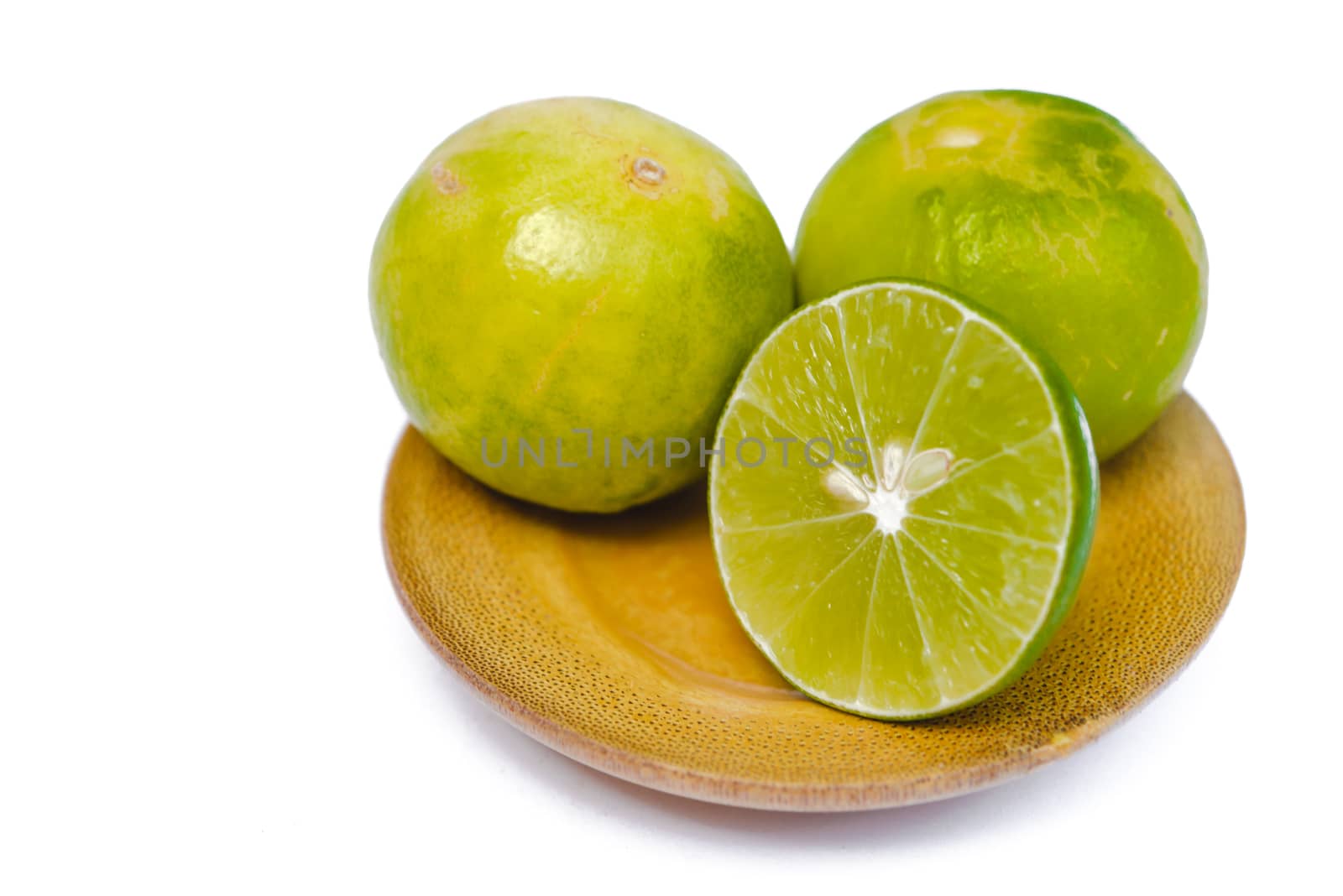 Lime placed in wooden tray on white background.