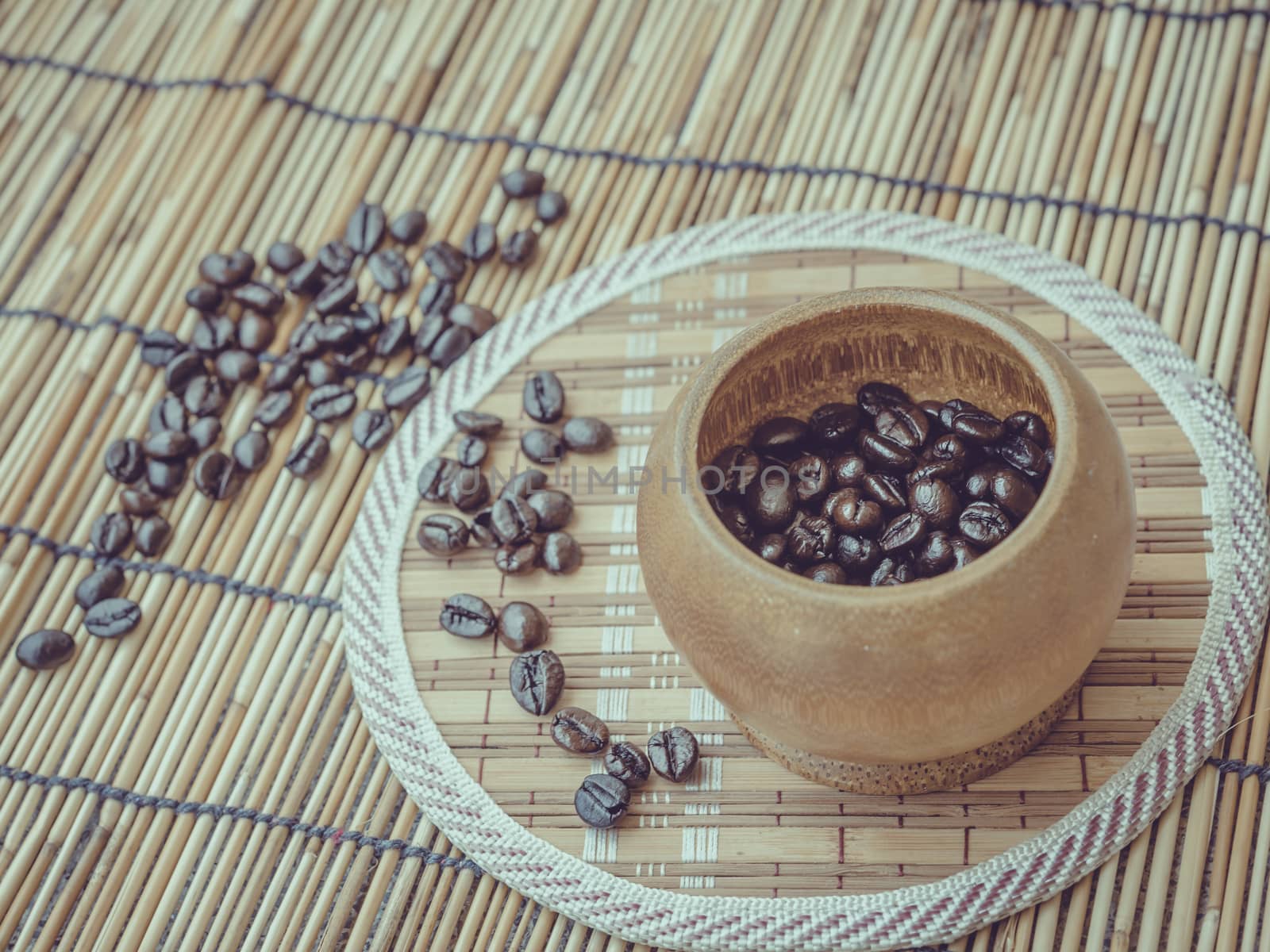 Coffee beans and coffee cup set on bamboo wooden background.Photo in retro color image style, Soft focus.