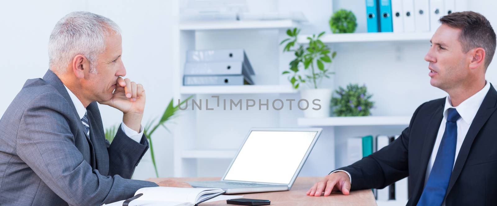 Two businessmen speaking and working at the office 