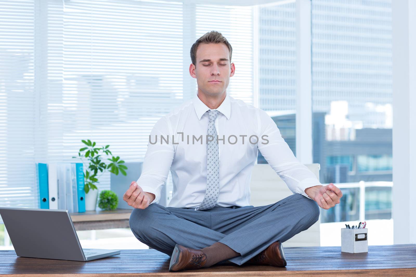 Zen businessman doing yoga meditation  by Wavebreakmedia