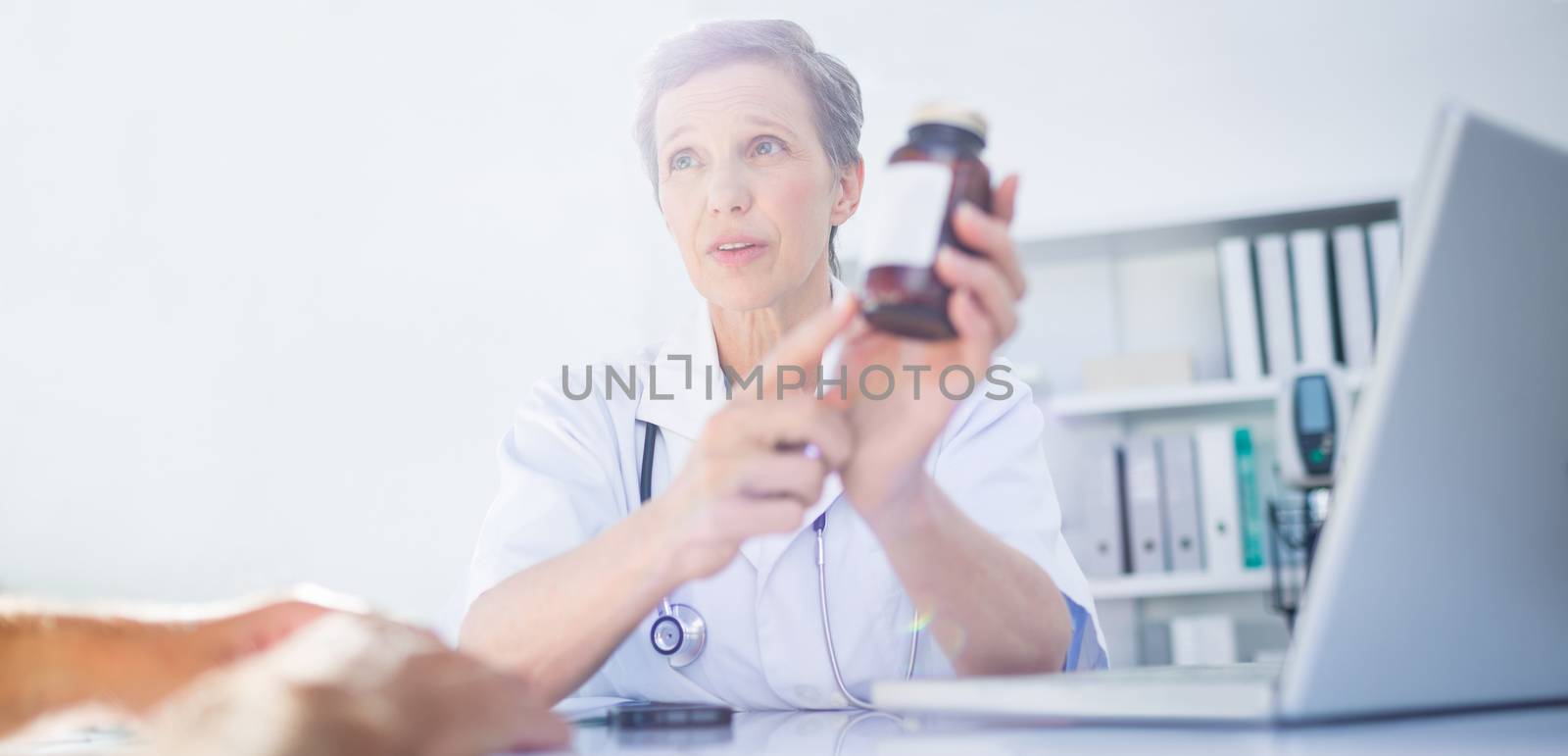 Female doctor holding a box of pills in medical office