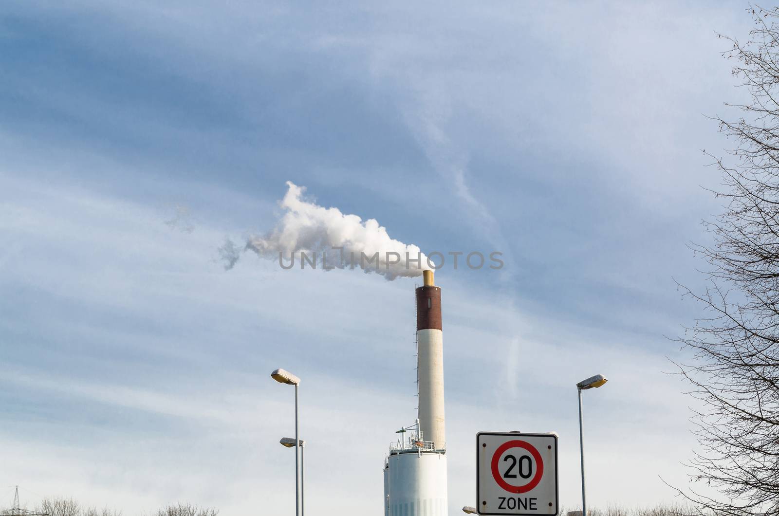 View of a power plant. Smoke comes from the chimney.