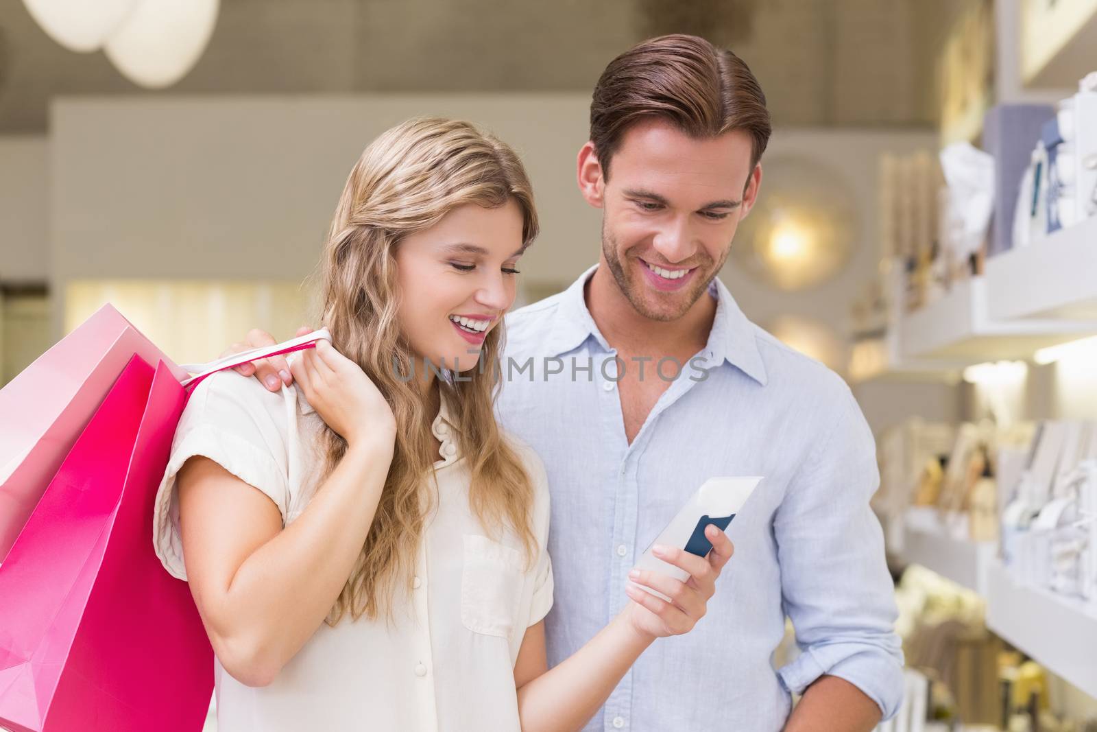 Portrait of a happy couple looking at beauty product by Wavebreakmedia