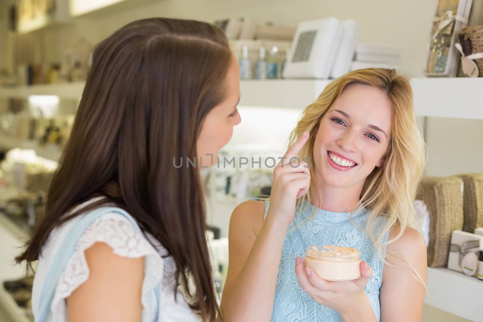 Happy blonde woman applying cosmetic products  by Wavebreakmedia