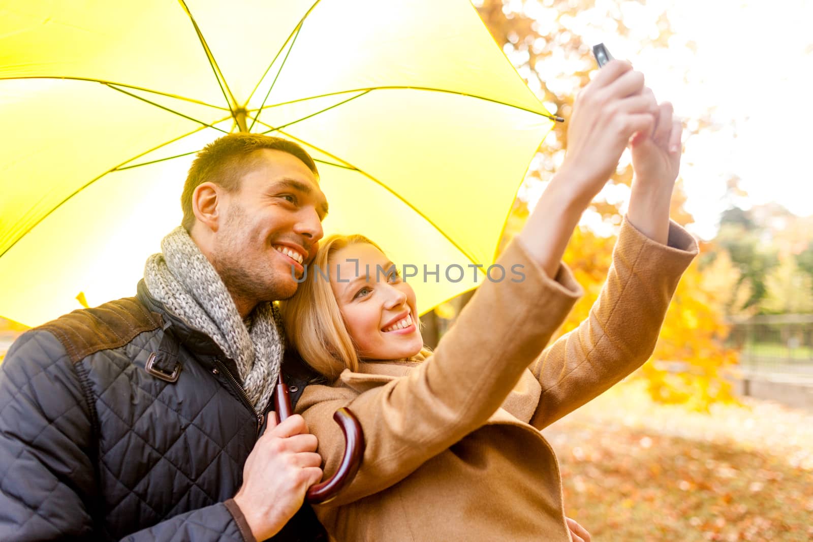 love, relationship, family, technology and people concept - smiling couple making selfie in autumn park