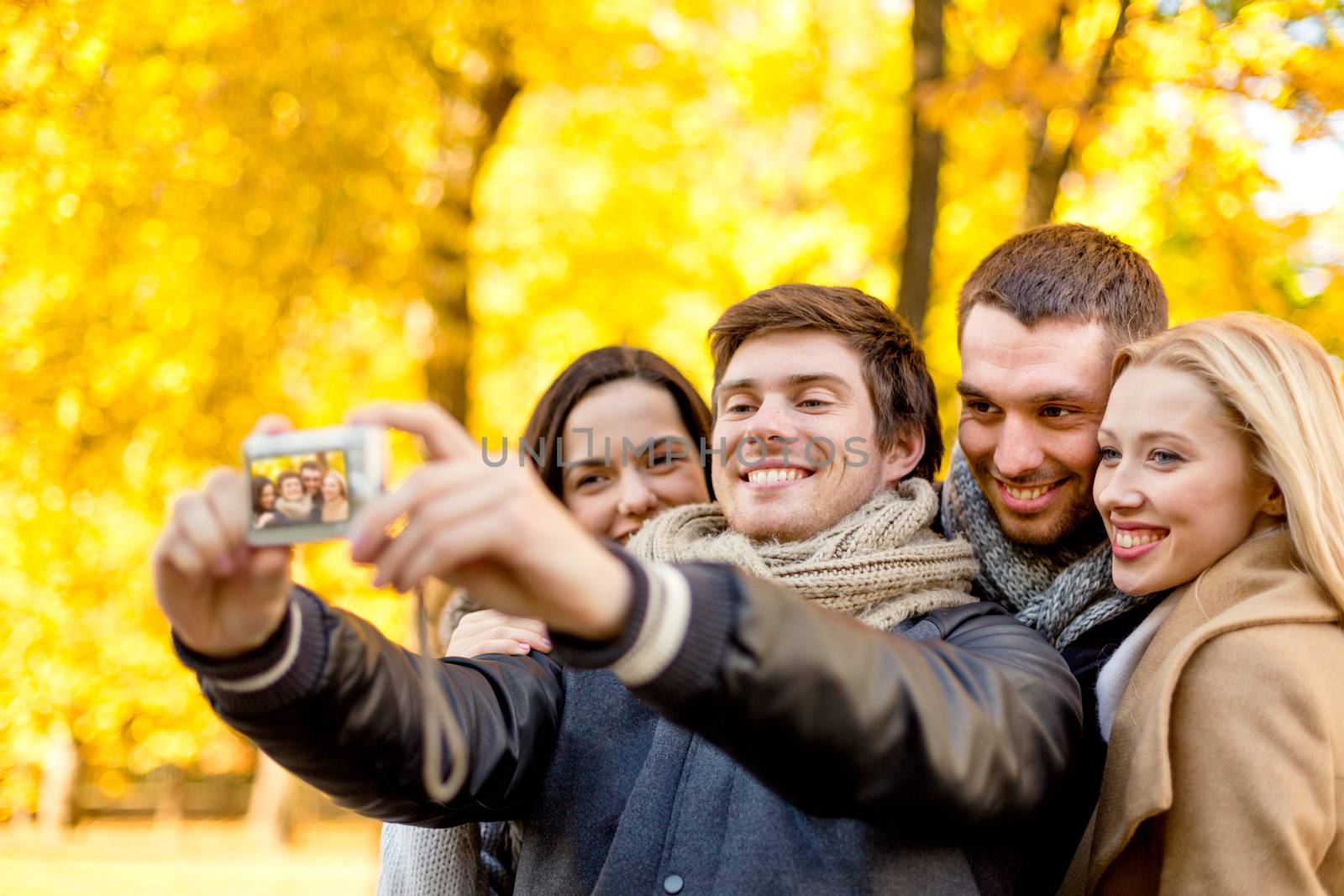 group of smiling men and women making selfie by dolgachov