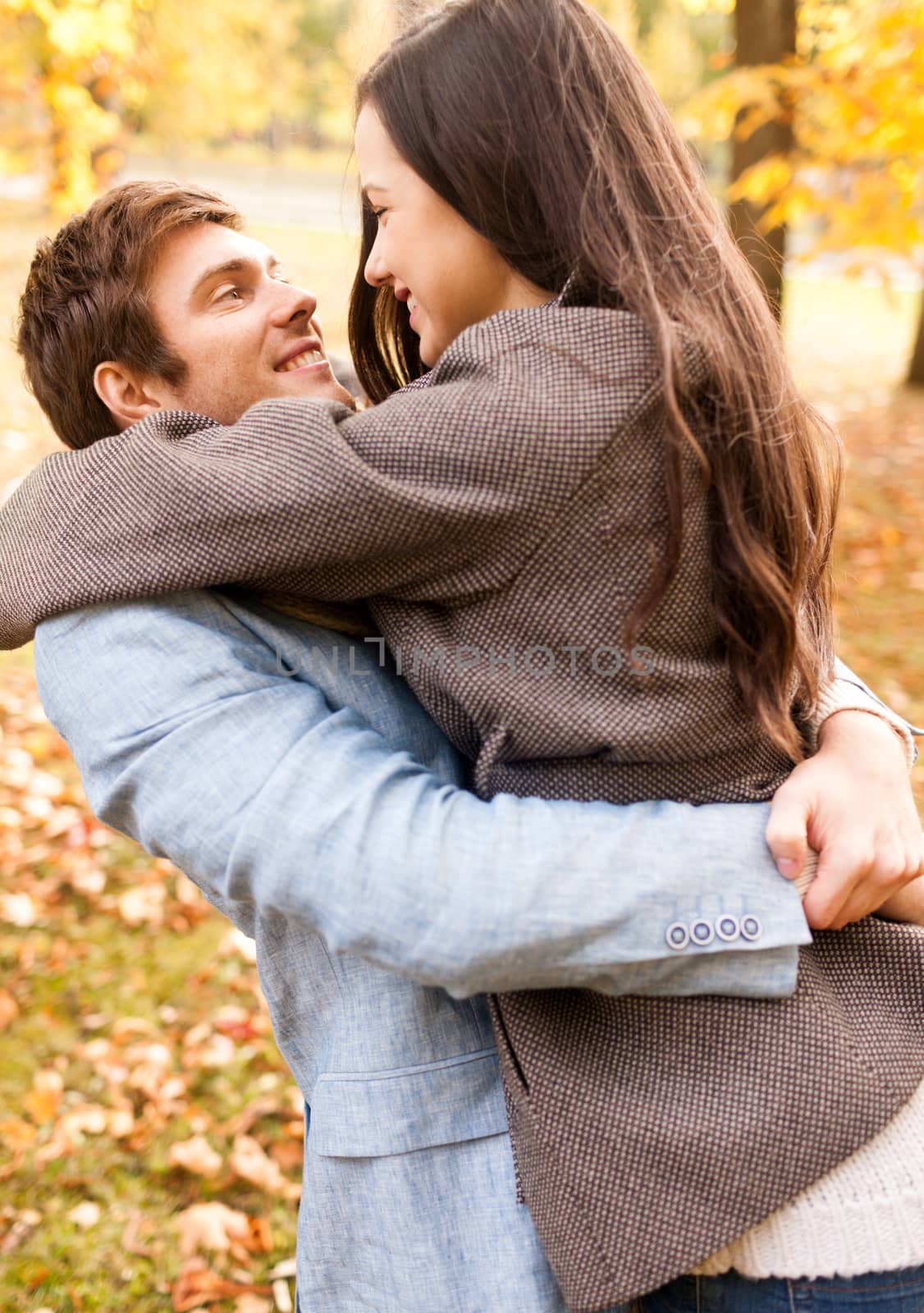 smiling couple hugging in autumn park by dolgachov