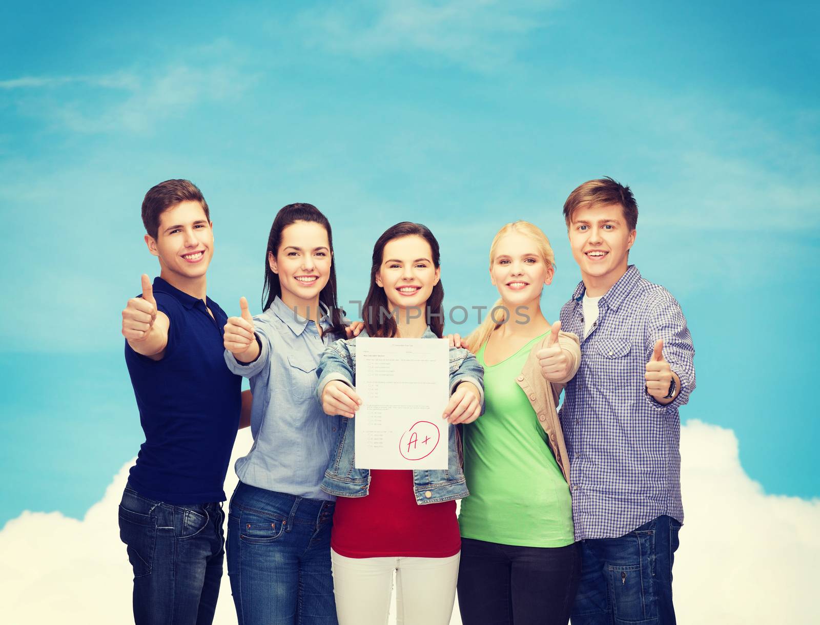 education and people concept - group of smiling students standing and showing test and thumbs up over blue sky background