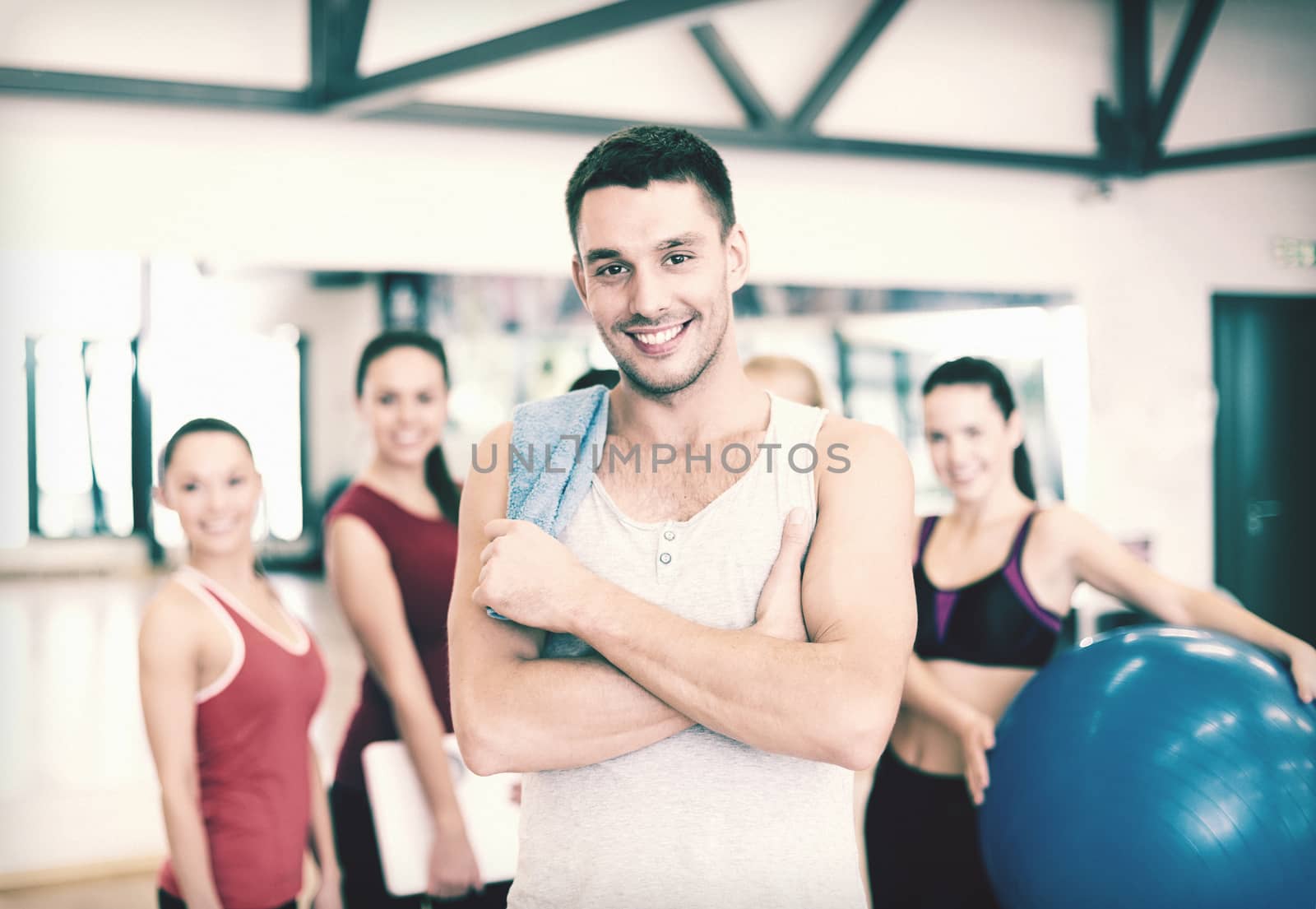 fitness, sport, training, gym and lifestyle concept - smiling man standing in front of the group of people in gym