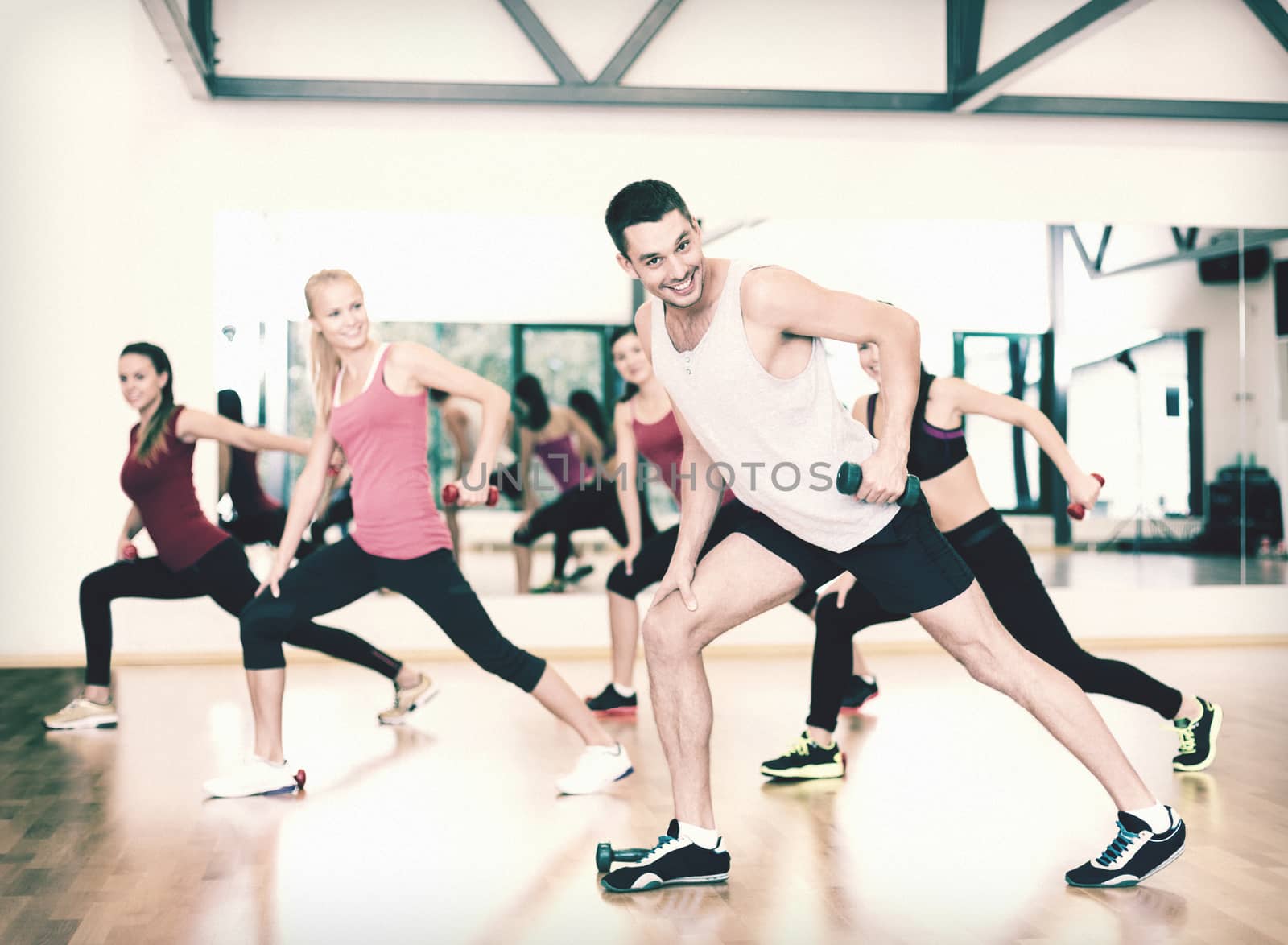 group of smiling people working out with dumbbells by dolgachov