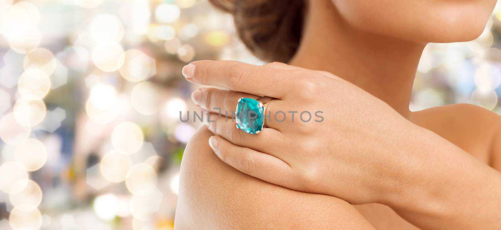 closeup of woman hand with big blue cocktail ring by dolgachov
