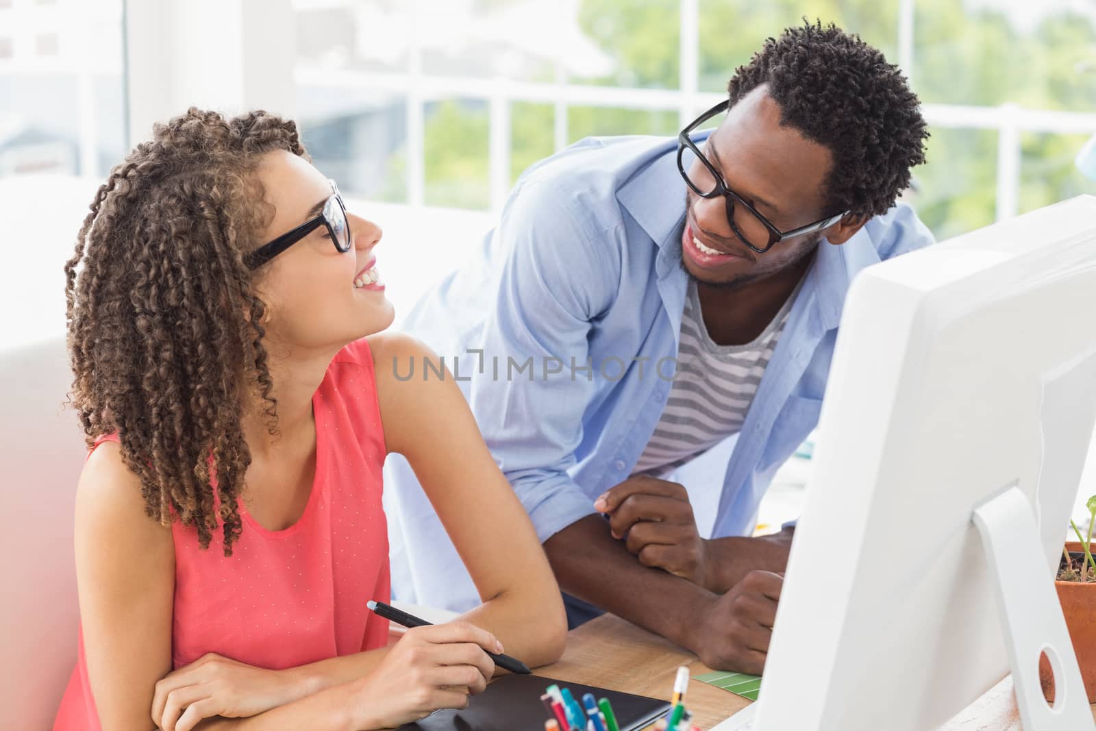 Two smiling creative business colleagues talking together