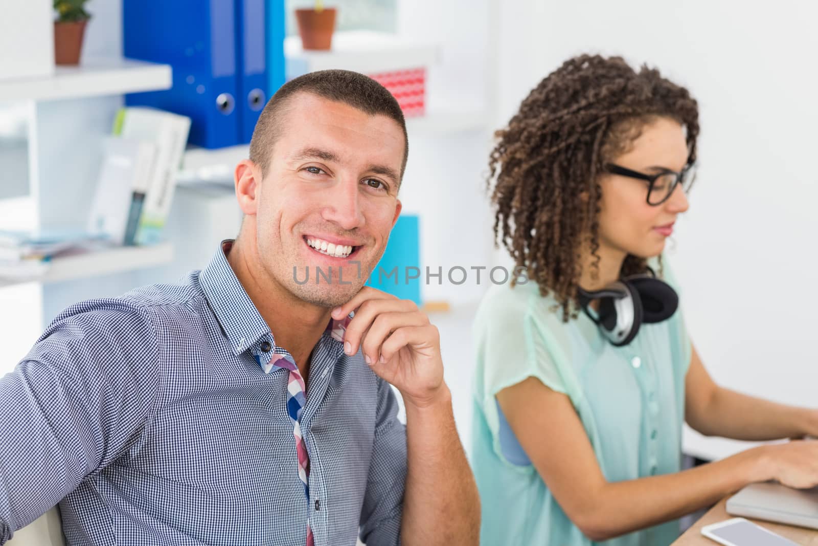Smiling businessman looking at camera in the office