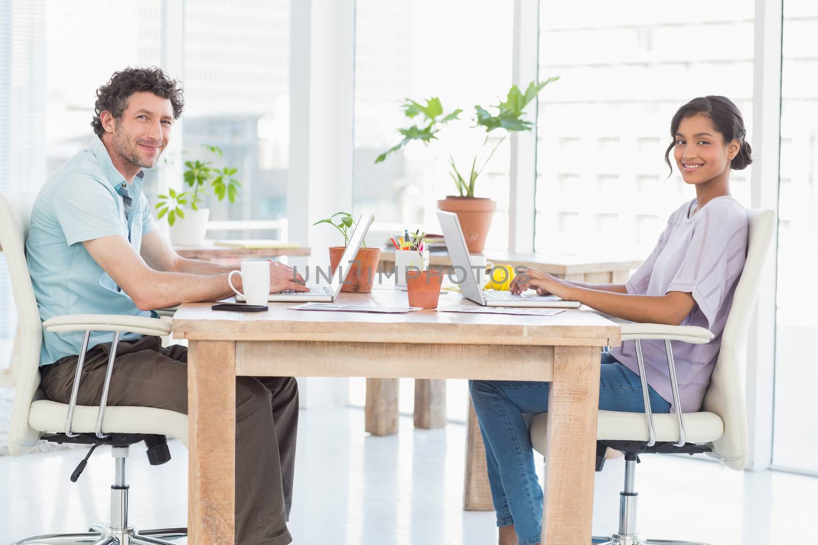 Casual business partners working on laptop by Wavebreakmedia